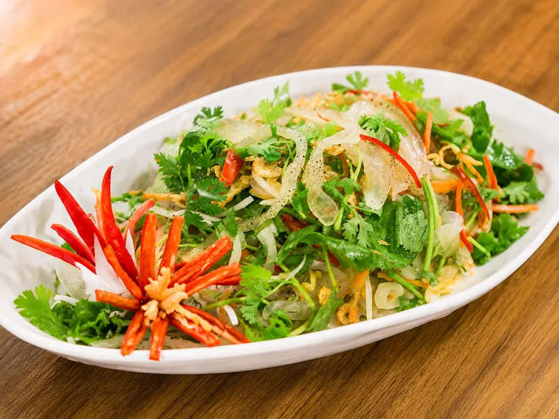 Nộm sứa sẽ bắt mắt hơn khi bày trên đĩa rộng và trang trí bằng lạc rang, rau mùi, ớt đỏ cùng xoài thái sợi.